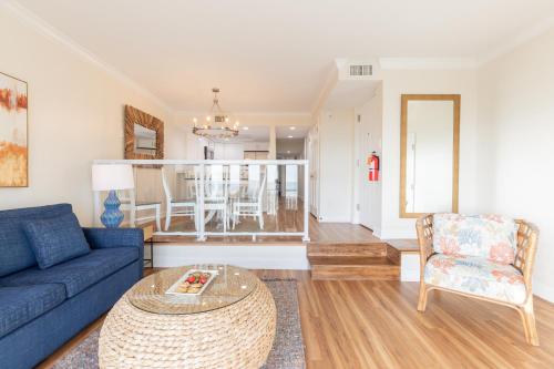 a living room with a blue couch and a table at La Mer Beachfront Resort in Cape May