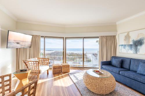 a living room with a blue couch and a table at La Mer Beachfront Resort in Cape May