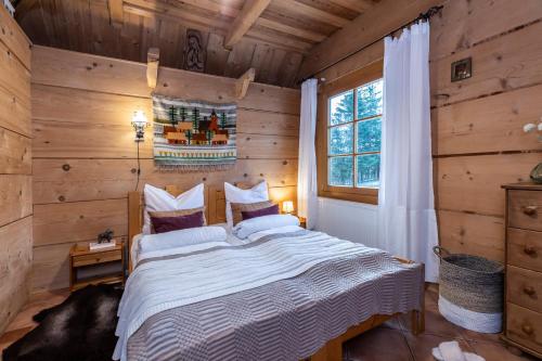 a bedroom with a bed in a log cabin at Apartamenty Panorama in Kościelisko