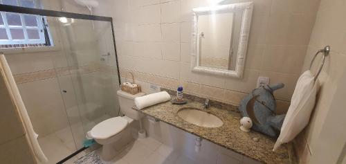 a bathroom with a toilet and a sink and a shower at Casa Praia do Forno Búzios, condomínio, 3 quartos in Búzios