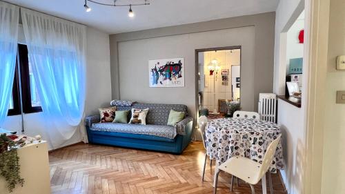a living room with a blue couch and a table at Behind On The Canalside Venice in Venice