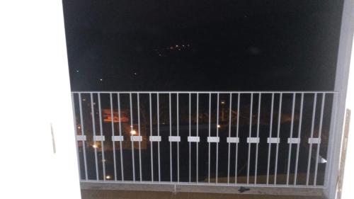 a view of a balcony with a gate at night at hospedagens regina in Águas de Lindóia