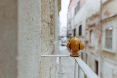 um objecto amarelo está sentado num corrimão perto de um edifício em Amiura B&B em Corato