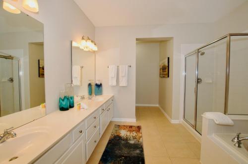 ein weißes Bad mit 2 Waschbecken und einer Dusche in der Unterkunft Vista Cay Luxury 4 bedroom condo (3120) in Orlando