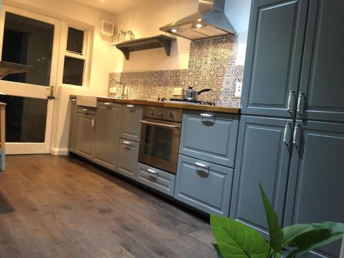 a large kitchen with stainless steel appliances and wooden floors at Home on Hamill Street in Belfast