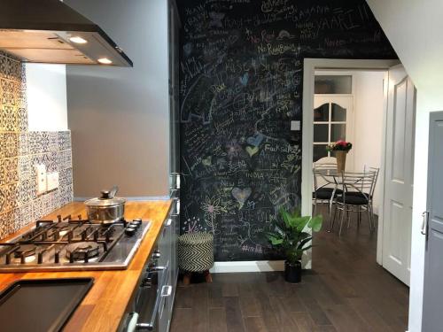 uma cozinha com um fogão e uma parede coberta de graffiti em Home on Hamill Street em Belfast