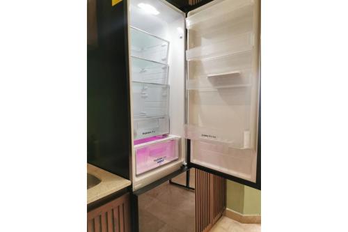 an empty refrigerator with its door open in a kitchen at Casa Mara 53 Luxury House in downtown Mérida in Mérida