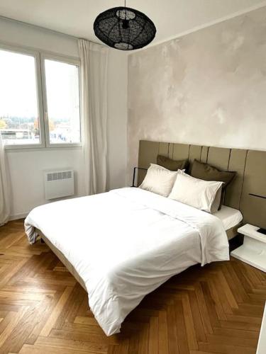 une chambre avec un grand lit blanc et une fenêtre dans l'établissement LE MÉDITERRANÉEN - Terrasse - Parking, à Montpellier