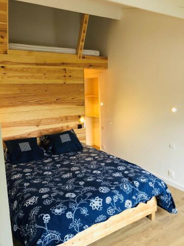 une chambre avec un lit avec un couvre-lit bleu et blanc dans l'établissement Uluwatu - cottage cosy, à Saint-Laurent-de-Médoc