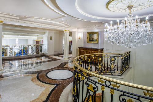 a large lobby with a chandelier and a staircase at Bentley London in London