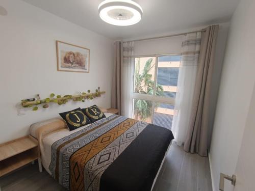 een slaapkamer met een bed en een groot raam bij JR apartment albir in Albir