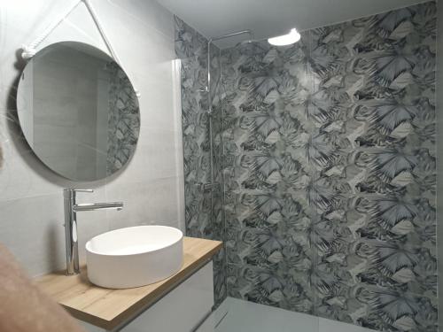 een badkamer met een wastafel en een spiegel bij JR apartment albir in Albir