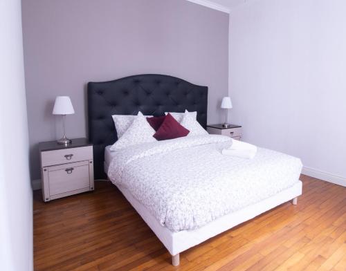 - une chambre avec un lit blanc et des oreillers rouges dans l'établissement Spacieux Cœur de Reims, à Reims