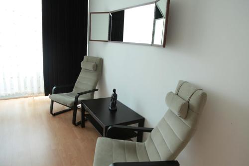 - un salon avec deux chaises, une table et un miroir dans l'établissement Aparthotel VEGA, à Berlin