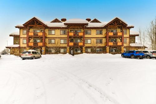 a large building with cars parked in a snow covered parking lot at First Tracks 4202 in Steamboat Springs
