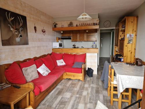 TrévigninにあるTERRES D'HISTOIRES Locationsのリビングルーム(赤いソファ付)、キッチン