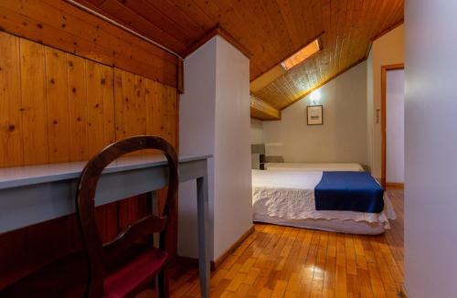 a bedroom with a bed and a chair at Hotel Sao Nicolau in Braga