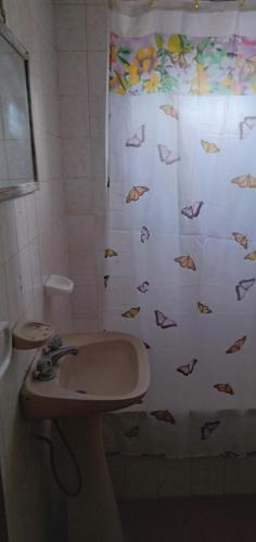 baño con lavabo y cortina de ducha con pescado en Santa Teresita en Santa Teresita
