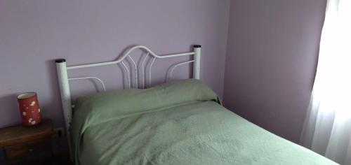 1 dormitorio con 1 cama con colcha verde en Santa Teresita en Santa Teresita