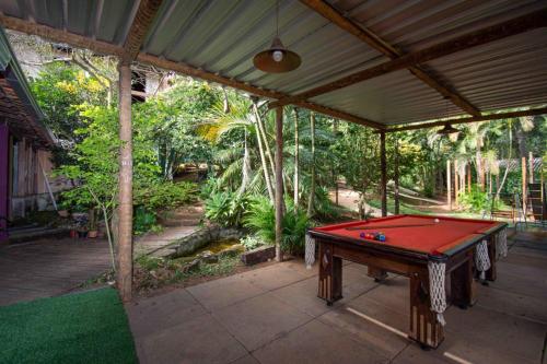 a screened porch with a red pool table in it at Pousada Evolucao in Macacos