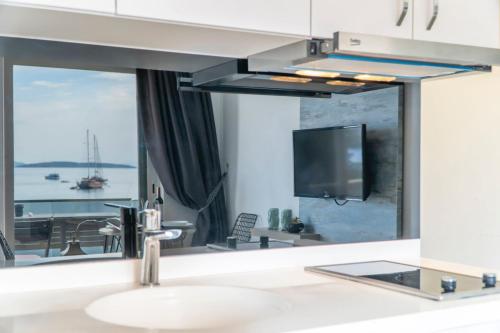 a bathroom with a sink and a large mirror at Seafront Flat with Breathtaking Sea View in Bodrum in Bodrum City