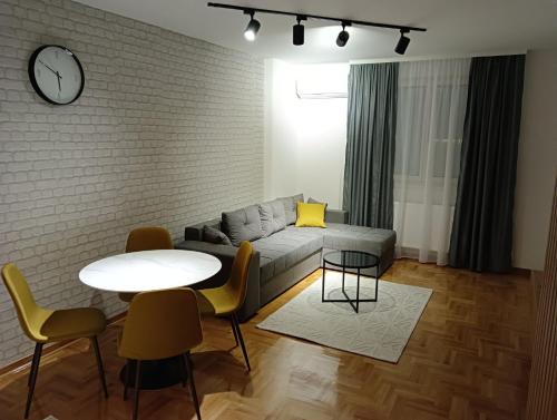 ein Wohnzimmer mit einem Sofa und einem Tisch in der Unterkunft Welcome Apartments in Niš