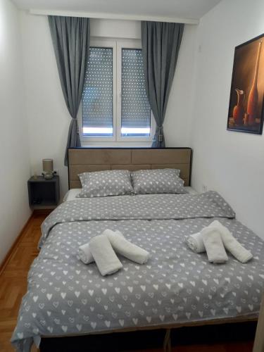 a bedroom with a bed with two pillows on it at Welcome Apartments in Niš