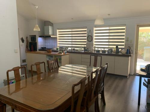 cocina y comedor con mesa y sillas en Lovely house in canning vale, en Perth