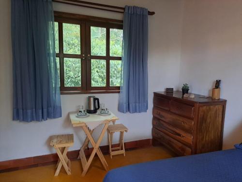 una camera con letto, tavolo e finestra di Suite Solteiro Cristal Rosa, Suites Ananda a Alto Paraíso de Goiás