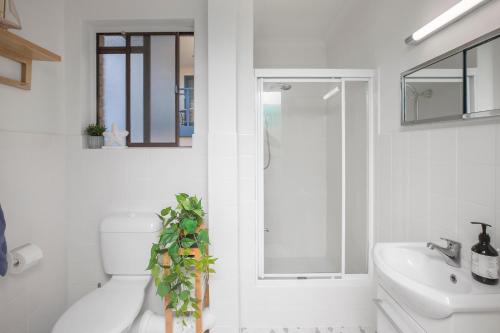 a white bathroom with a toilet and a sink at BJ Mick's Lakefront Apartment in Forster