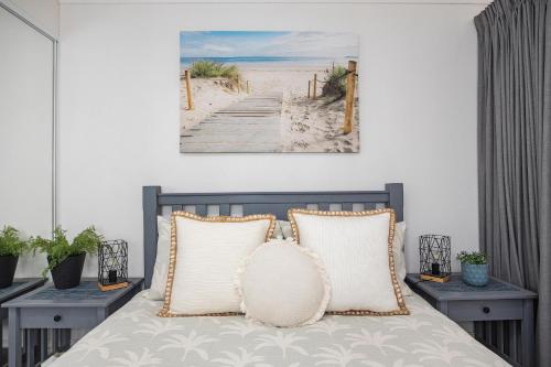a bedroom with a bed with a painting on the wall at BJ Mick's Lakefront Apartment in Forster