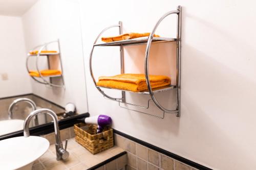 ein Bad mit Waschbecken und Handtüchern an der Wand in der Unterkunft COSTANERA APART in Villa María