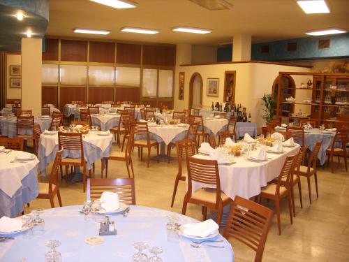 a dining room with tables and chairs with white tablecloths at Cannone d'Oro in Sale