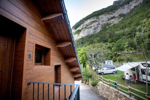 a building with a balcony with a view of a mountain at Camping Valle de Bujaruelo in Torla