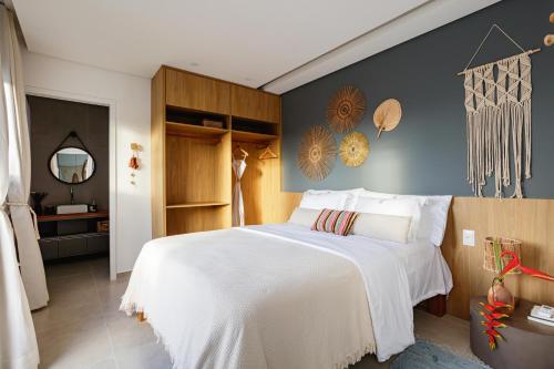 a bedroom with a large white bed and a mirror at VILA PITHAYA - Casa Jambo Rosa in Japaratinga