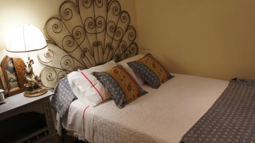 a bedroom with a bed with pillows and a lamp at Casa Rural Oliveira do Bairro in Oliveira do Bairro