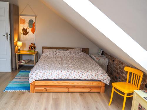Nowe Miasto的住宿－Sielski Dom，一间卧室配有一张床和一张黄色椅子