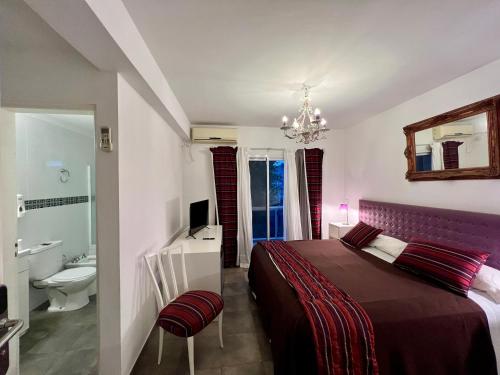 a bedroom with a bed and a bathroom with a sink at Apart & Hotel Neptuno in Valeria del Mar