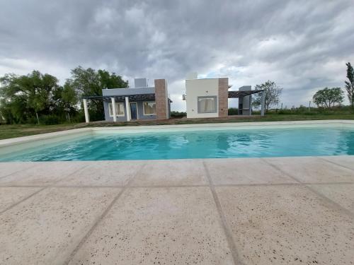 Villa con piscina frente a una casa en Complejo Blend en San Rafael