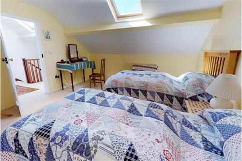 a bedroom with two beds with a quilt at Afallon Aberdaron in Aberdaron