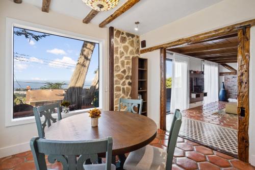 帕西菲卡的住宿－@ Marbella Lane - 3BR Home w/sweeping ocean views!，一间带桌椅和大窗户的用餐室
