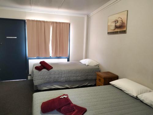 坎納馬拉的住宿－Billabong Hotel Motel，酒店客房设有两张床和窗户。