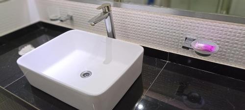 lavabo blanco en el baño con espejo en Departamento 3 Ambientes con Cochera MDQ PLAYA SOLO FAMILIAS en Mar del Plata