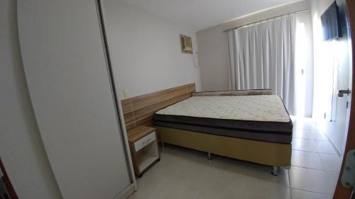 Dormitorio pequeño con cama y espejo en Apartamento encantador de frente ao lago Corumbá, en Caldas Novas