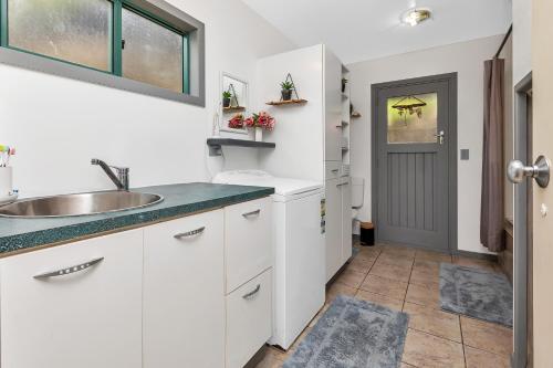 a kitchen with white cabinets and a sink at Mi Castillo on Hatea Drive in Whangarei