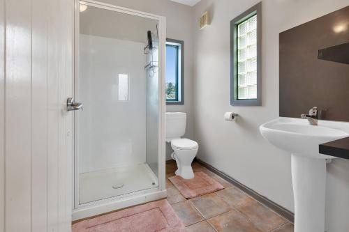 a bathroom with a shower and a toilet and a sink at Mi Castillo on Hatea Drive in Whangarei