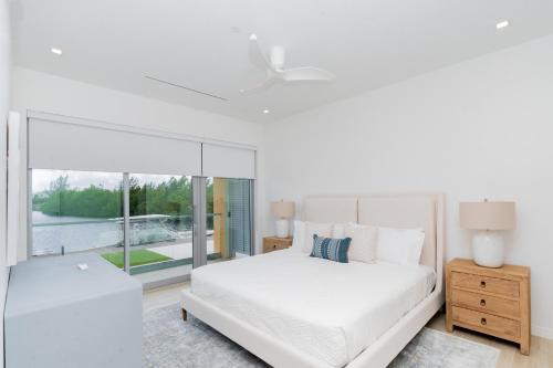 a white bedroom with a large bed and a window at ONE Canal Point in Upper Land