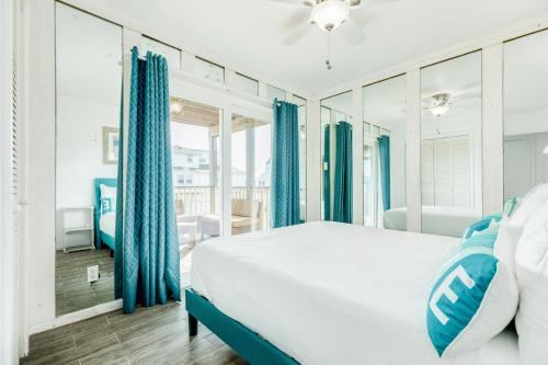 a bedroom with a large bed and blue curtains at Casa Del Alba in Galveston