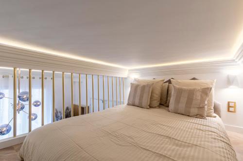 une chambre blanche avec un grand lit et une fenêtre dans l'établissement le studio des Champs elysees, à Paris