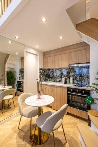 une cuisine avec une table et des chaises dans une pièce dans l'établissement le studio des Champs elysees, à Paris